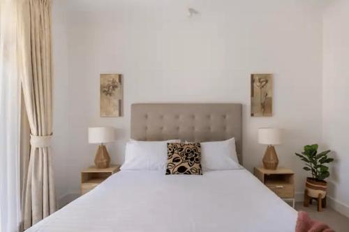 NorthfieldModern Mansion in Lightsview By Host Solutions的卧室里有一张白色的大床，床边还有两盏灯