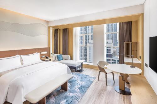 a hotel room with a bed and a table at The Westin Wuhan Hanyang in Wuhan