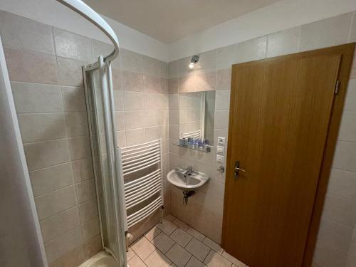 a bathroom with a sink and a shower at Penzion U Šlechtů in Sněžné