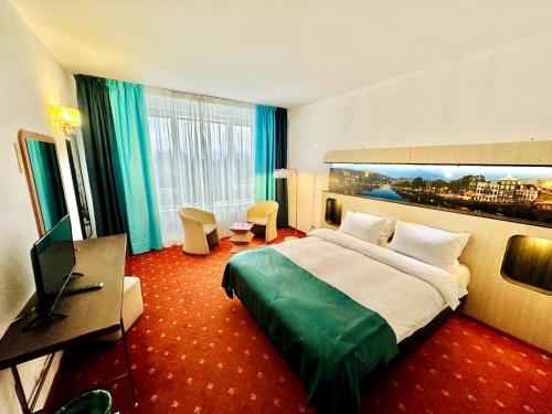 a hotel room with a bed and a flat screen tv at Atrium Panoramic Hotel & Spa in Predeal