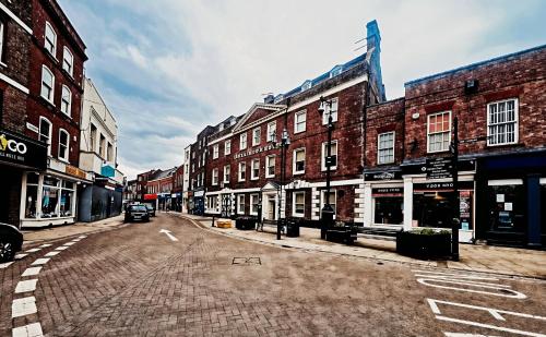 an empty city street with buildings and a car on it at The Rose And Crown Hotel in Wisbech