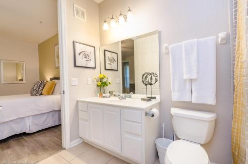 een badkamer met een wastafel, een toilet en een bed bij Vista Cay 86 by Top Villas in Orlando