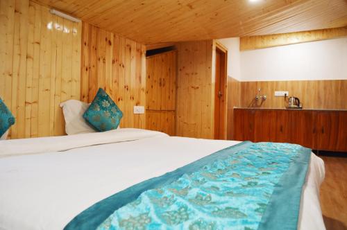 a bedroom with a bed and wooden walls at Manali Outdoor Retreat by Sheosante in Manāli