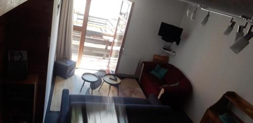 uma sala de estar com um sofá, uma mesa e uma janela em Les Isards Pied des pistes em Ax-les-Thermes
