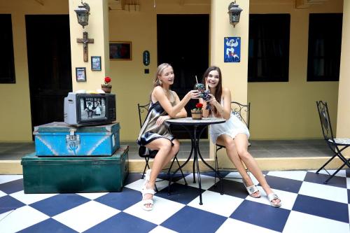 two women sitting at a table taking a picture at The Quba Boutique Hotel Pattaya in Pattaya Central