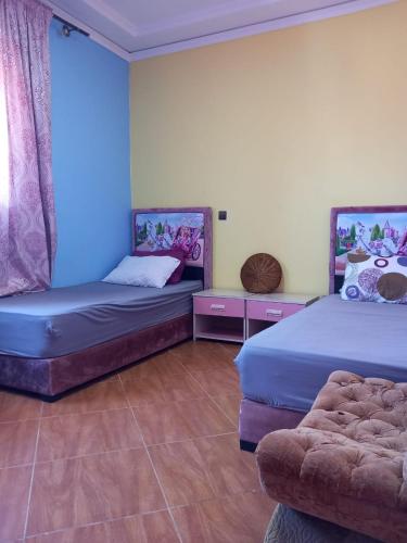 ein Zimmer mit 2 Betten und einem Sofa darin in der Unterkunft appartement à larache in Larache