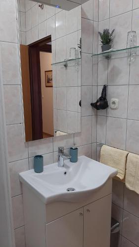 a bathroom with a white sink and a mirror at Apartments IDA Sucuraj in Sućuraj