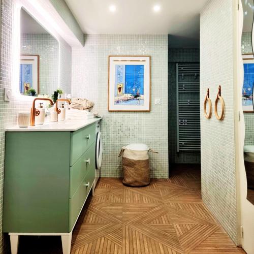 uma casa de banho com um armário verde e um lavatório em LA CAMPAGNE à PARIS em Saint-Cloud