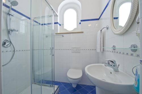 een badkamer met een wastafel, een toilet en een douche bij Villa Panorama in Praiano