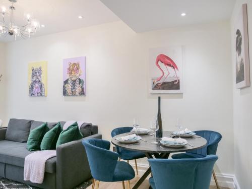 sala de estar con sofá, mesa y sillas en Urban getaway in the heart of South Kensington en Londres