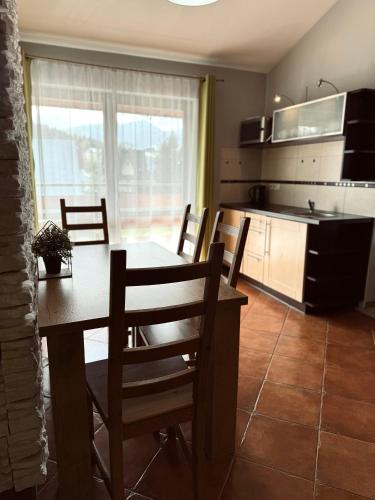 eine Küche und ein Esszimmer mit einem Tisch und Stühlen in der Unterkunft Apartamenty U Anki in Zakopane