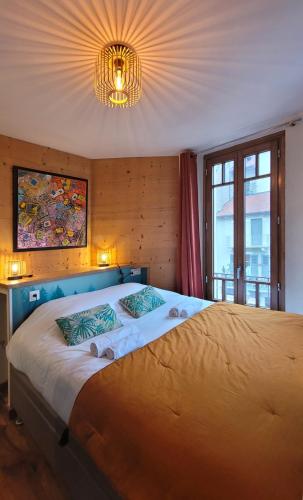- une chambre avec un grand lit et un lustre dans l'établissement L'Isle - Lofts & Lakes certified 5-stars, à Annecy