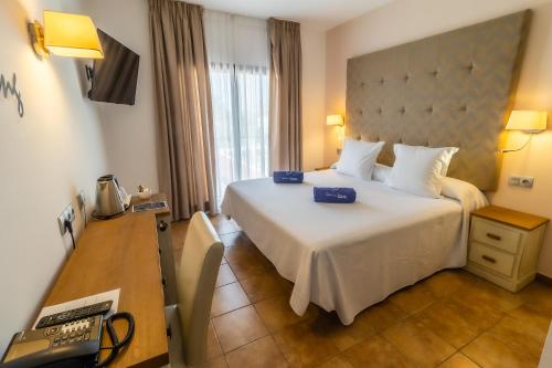 una camera con un grande letto bianco e una scrivania di Paloma Blanca Boutique Hotel- Adults Recommended a Marbella