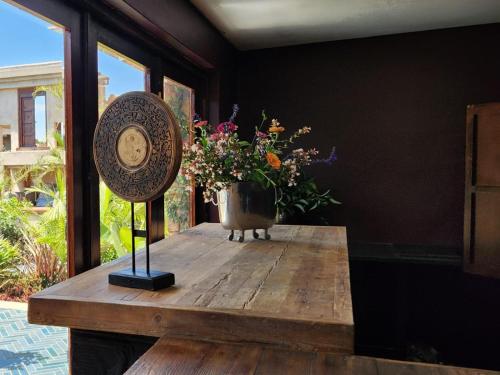 a wooden table with a vase of flowers on it at Bella Bohemia Spa, Venue and Guest Farm in Roodeplaat