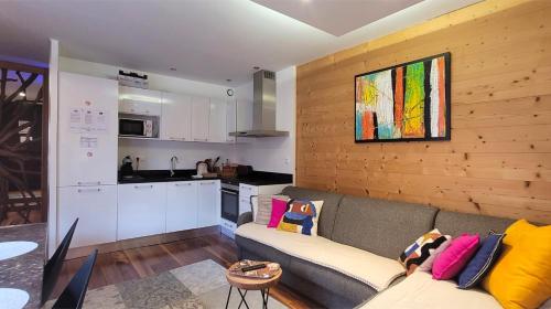 een woonkamer met een bank en een keuken bij L'Isle - Lofts & Lakes certified 5-stars in Annecy