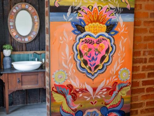 un baño con una pintura de un león en la puerta en Bella Bohemia Spa, Venue and Guest Farm, en Roodeplaat
