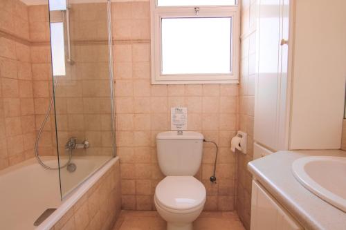 La salle de bains est pourvue de toilettes, d'une douche et d'un lavabo. dans l'établissement Phaedrus Living Modern City View Flat Nafi, à Limassol