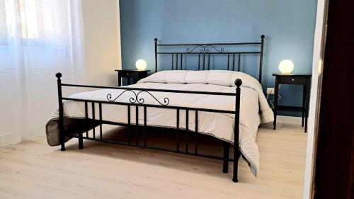 a black bed in a bedroom with two night stands at Anninnìa Guest House B&B - GhiIarza in Ghilarza