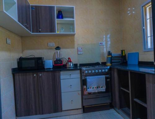 a kitchen with a stove and a counter top at Exquisite luxurious 2 bedroom Apartment. in Gwarinpa