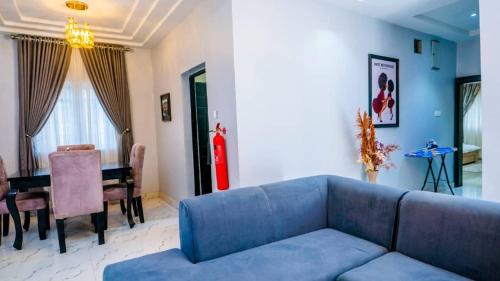 a living room with a blue couch and a table at Exquisite luxurious 2 bedroom Apartment. in Gwarinpa