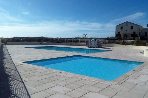 - une piscine d'eau bleue sur une terrasse dans l'établissement Superbe T2 dans Rés Bleu Marine - Face à l'Ocean, à Lacanau