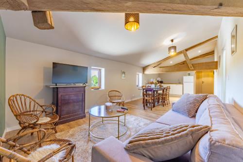 a living room with a couch and a tv at Ô DOMAINE DU ROUSSILLON 