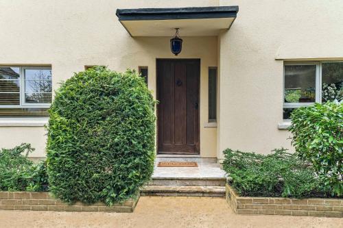 a house with two large bushes in front of a door at Villa 10 min bus to Oxford train in Oxford