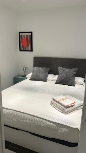 a bedroom with a large bed with white sheets at LOFT URBANO in Béjar