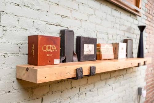 a shelf on a brick wall with books on it at Cityscape Elegance - Stylish Skyline Views Retreat in Bangor