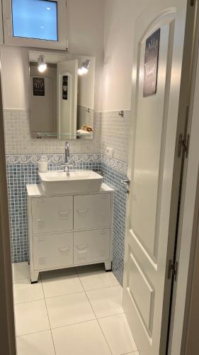 a white bathroom with a sink and a mirror at LOFT URBANO in Béjar