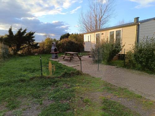 einen Hinterhof mit einem Picknicktisch und einem Haus in der Unterkunft Mobilhome Indien in Oye-Plage