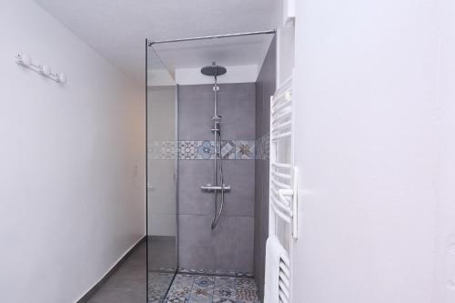 a shower with a glass door in a bathroom at T3 avec jardin dans Villa Rocaille in Cassis