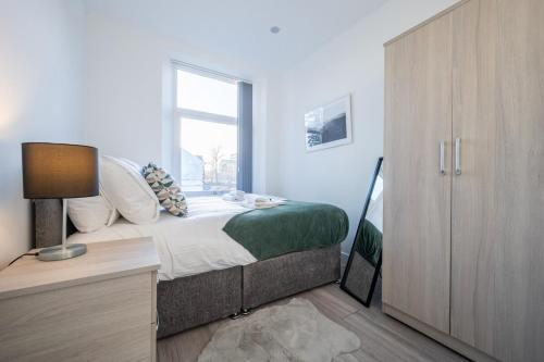 a bedroom with a bed and a desk and a window at Stylish 2 Bedroom - Church View 3 by Tŷ SA in Newport