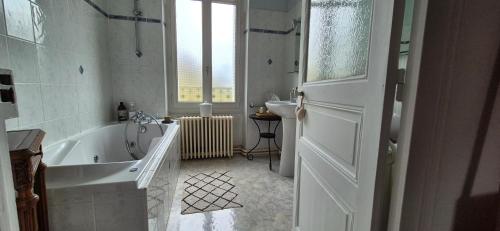 a white bathroom with a tub and a sink at Demeures ressourçantes - Le Vallon in Saint-Martin-de-Saint-Maixent