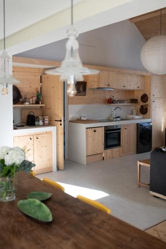 une cuisine ouverte avec des placards en bois et une table dans l'établissement Loft l'Écluse 2, parking gratuit, à Saint-Valery-sur-Somme