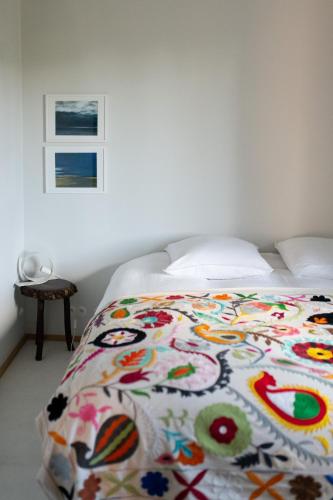 - un lit avec une couverture colorée dans une chambre dans l'établissement Loft l'Écluse 2, parking gratuit, à Saint-Valery-sur-Somme