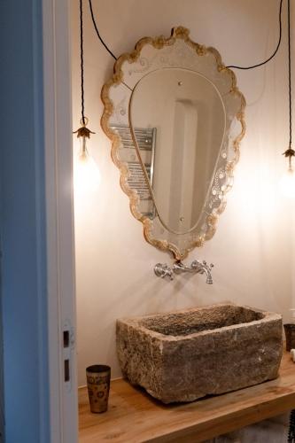 un miroir sur un mur avec un lavabo en pierre dans l'établissement Loft l'Écluse 2, parking gratuit, à Saint-Valery-sur-Somme