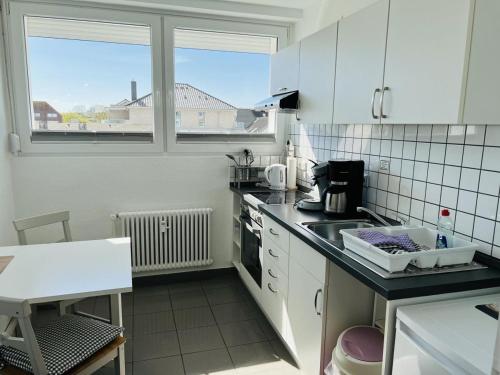 eine Küche mit weißen Schränken und einer Arbeitsplatte in der Unterkunft Hansastr. 1 W12 in Scharbeutz