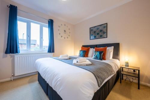 a bedroom with a large bed with blue curtains at Summer Close by Tŷ SA in Bristol