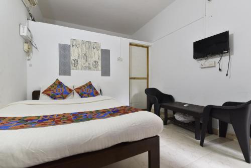 a bedroom with a bed and a desk and a television at Euphoria Stays in Anjuna in Anjuna