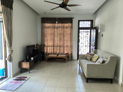 a living room with a couch and a ceiling fan at Garden Homestay in Kulai