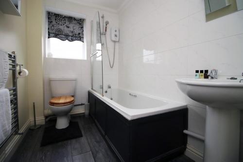 a white bathroom with a toilet and a sink at The Nook by Tŷ SA - Near Bike Park Wales in Nelson