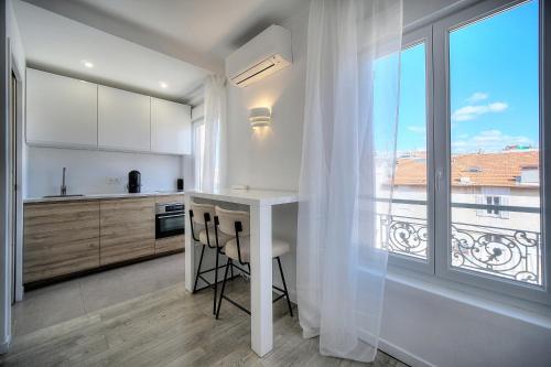 une cuisine avec une table et une grande fenêtre dans l'établissement Immogroom - Luminious T2 - Center - AC - Wifi, à Cannes