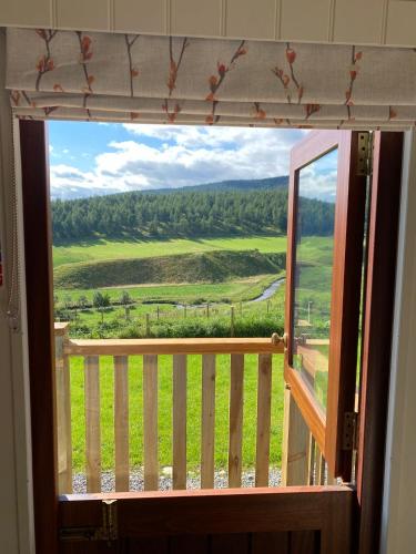 a window with a view of a green field at Ledmacoy Shepherds Huts in Strathdon