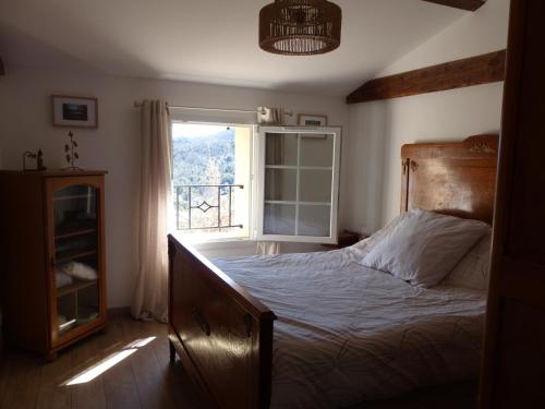 a bedroom with a bed and a window at Le Murmure des Cèdres - Gîte en Cévennes in Saint-André-de-Majencoules