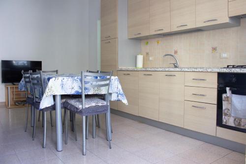 een keuken met een tafel met stoelen en een wastafel bij Casa Rosa sul Mare in Capo dʼOrlando