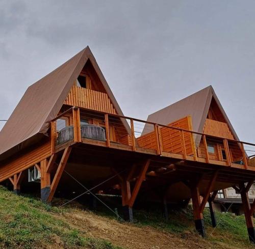 a large wooden house with a large roof at Glamping Čelig 