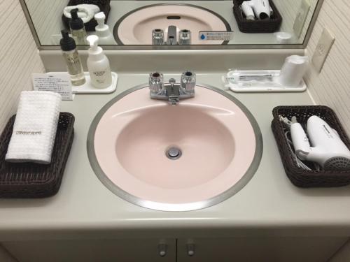 a bathroom counter with a sink and towels on it at Urvest Hotel Kamata in Tokyo