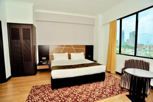 ein Hotelzimmer mit einem Bett und einem großen Fenster in der Unterkunft REGALPARK Hotel Kuala Lumpur in Kuala Lumpur