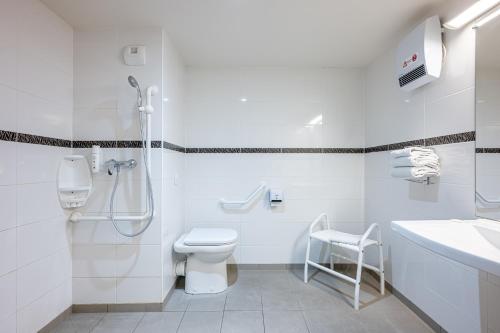 La salle de bains blanche est pourvue de toilettes et d'un lavabo. dans l'établissement Ace Hotel Poitiers, à Poitiers